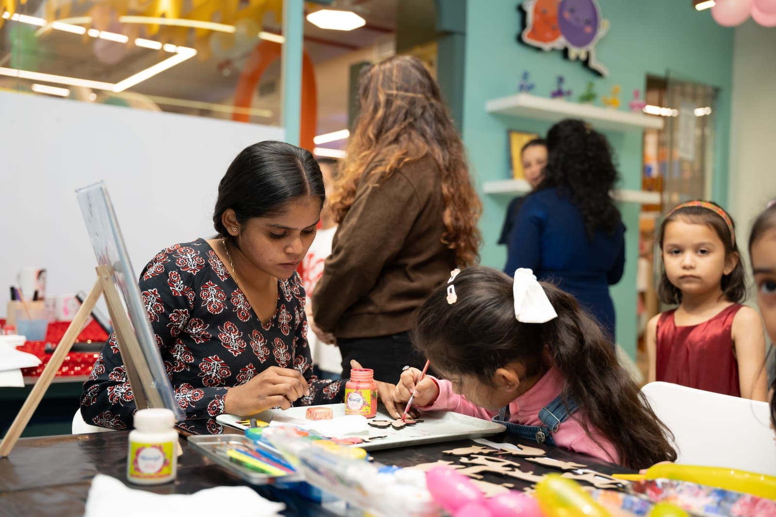Kids painting wooden cut-outs at an art event