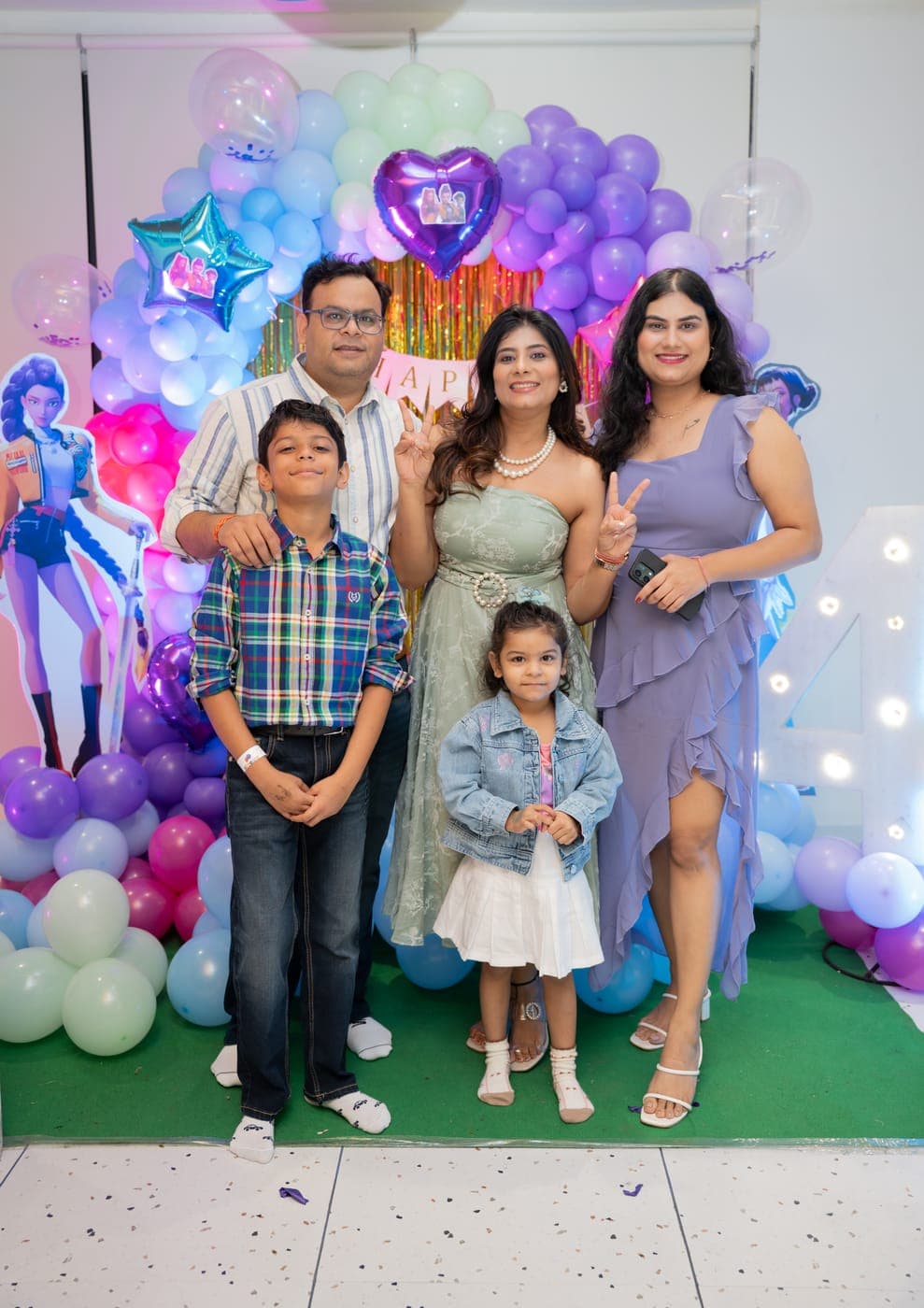 Family portrait in front of a purple balloon backdrop