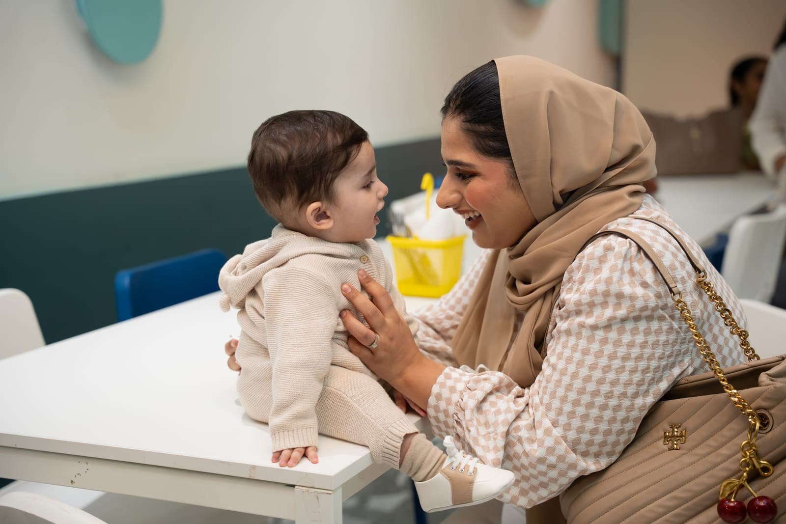 Mother smiling at her baby at the café table