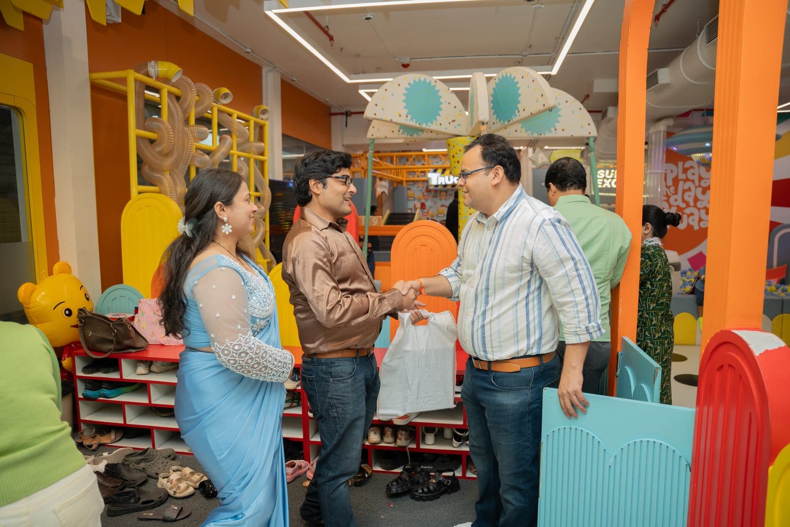 Parents shaking hands and chatting in the play zone