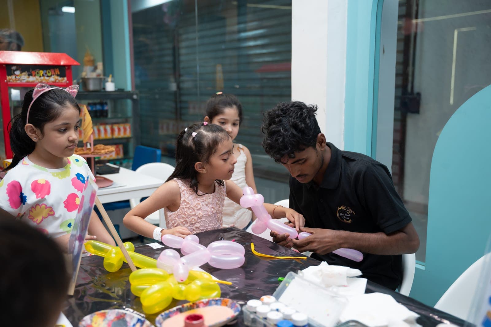 Kids watching a balloon-twisting workshop