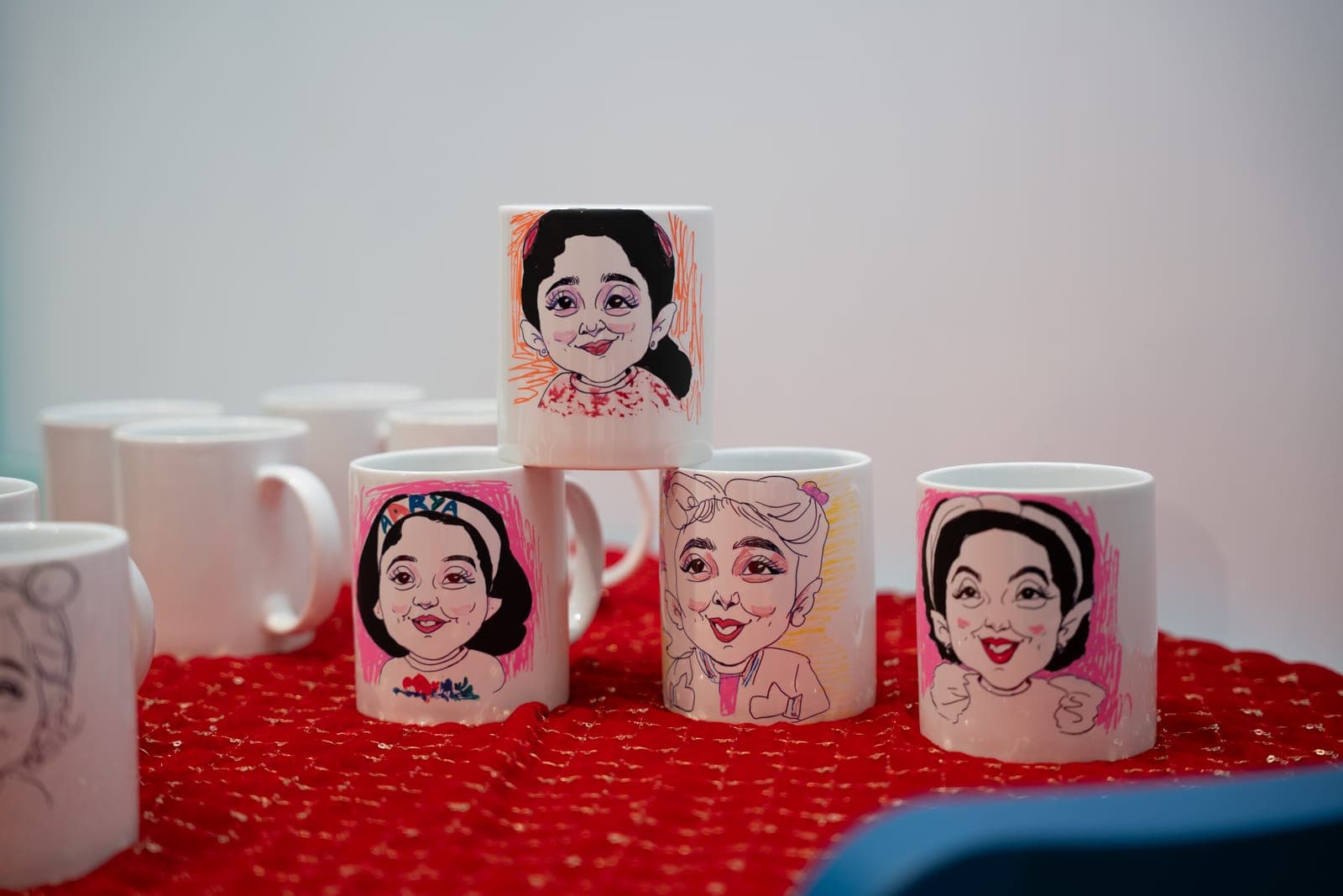 Mugs with hand-drawn caricatures from a mug art workshop