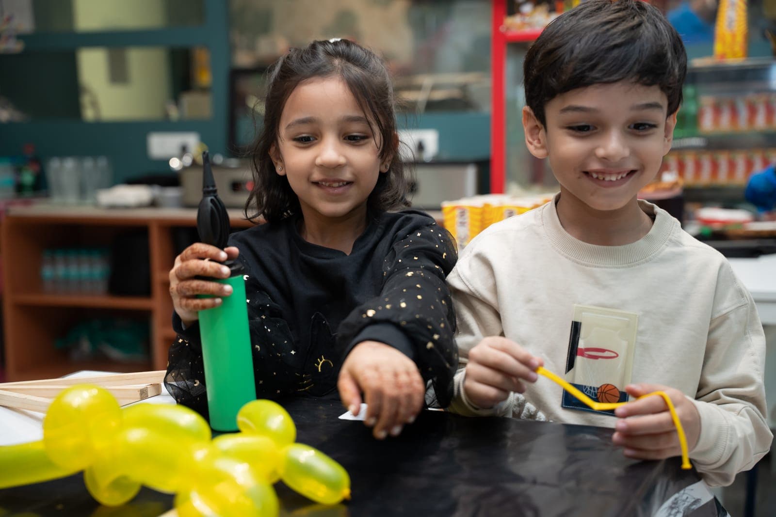 Two kids smiling at the balloon-twisting table